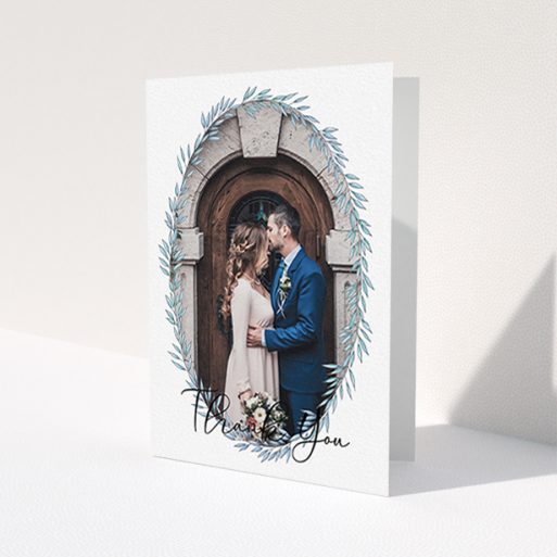 A wedding thank you card design named 'Tussled Wreath Frame'. It is an A6 card in a portrait orientation. It is a photographic wedding thank you card with room for 1 photo. 'Tussled Wreath Frame' is available as a folded card, with mainly blue colouring.