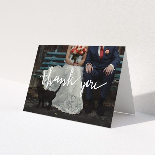 A wedding thank you card template titled 'Wonky thank you'. It is an A5 card in a landscape orientation. It is a photographic wedding thank you card with room for 1 photo. 'Wonky thank you' is available as a folded card, with mainly white colouring.