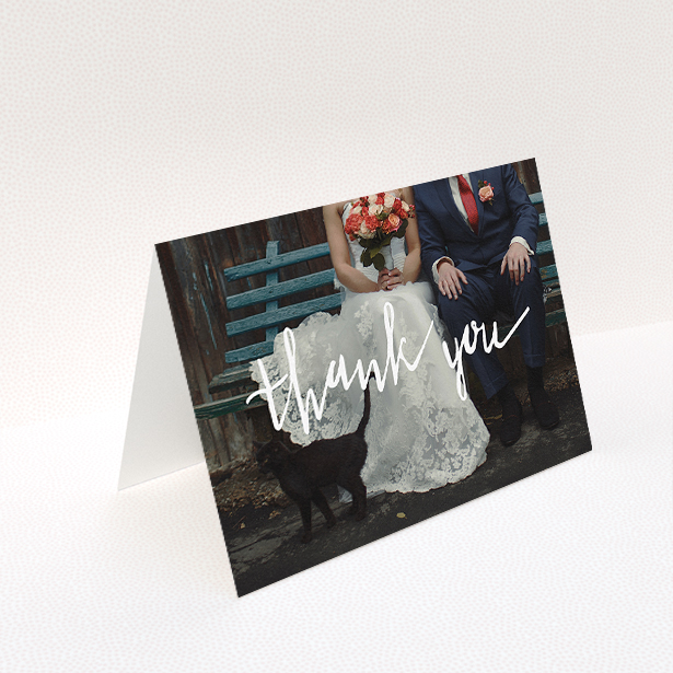 A wedding thank you card template titled "Wonky thank you". It is an A5 card in a landscape orientation. It is a photographic wedding thank you card with room for 1 photo. "Wonky thank you" is available as a folded card, with mainly white colouring.