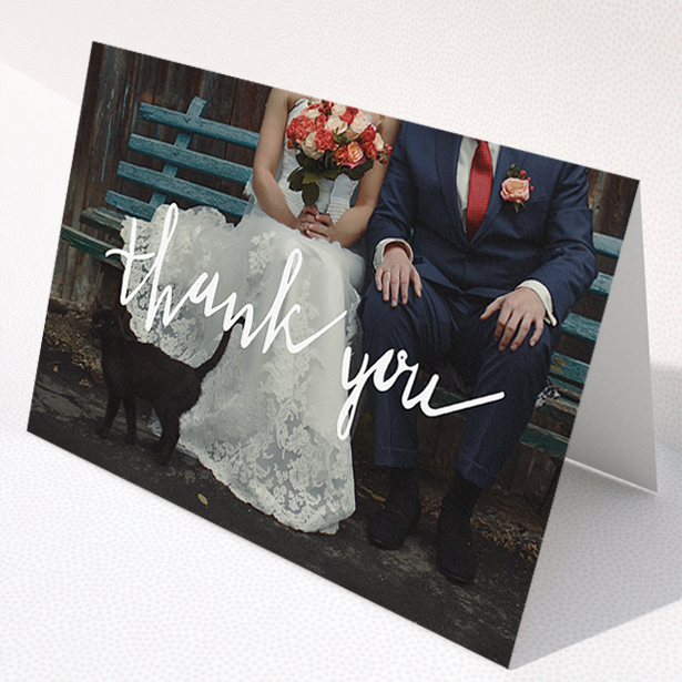 A wedding thank you card template titled "Wonky thank you". It is an A5 card in a landscape orientation. It is a photographic wedding thank you card with room for 1 photo. "Wonky thank you" is available as a folded card, with mainly white colouring.